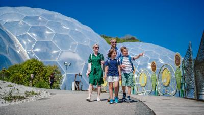 Family walking towards the camera away from the Eden Project Biomes